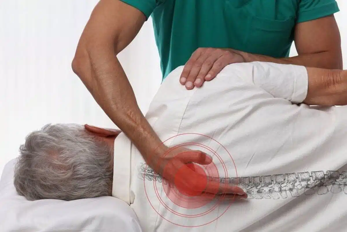 Natural pain management physician helping patient with back pain
