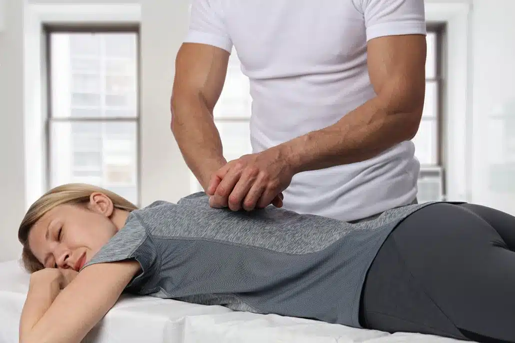 chiropractor helping patient with back pain