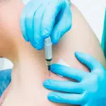 doctor giving patient trigger point injection on back