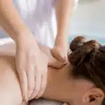 chiropractor giving patient a neck massage